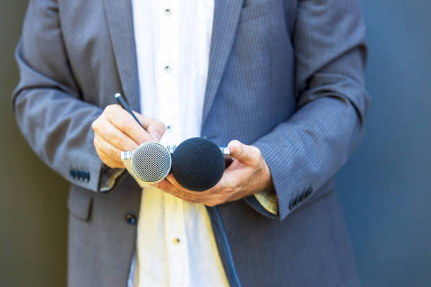 istock Press or news correspondent holding microphone making media interview. Investigative journalism concept. 1461051908