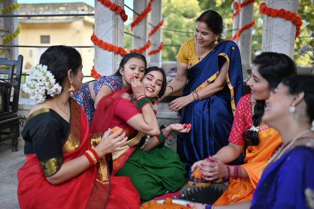 istock Mother feeding her daughter Indian sweet (motichur) laddoos during a traditional function 1461053445