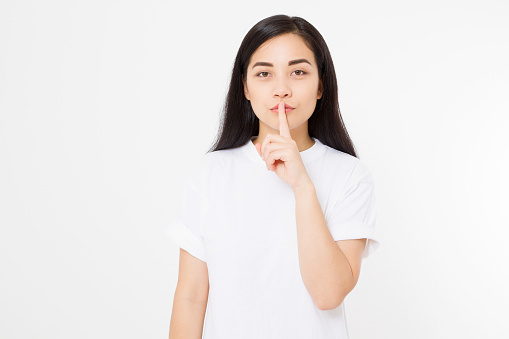 Shh hush sign. Young asian woman isolated on white background in blank summer t shirt. Copy space. Japanese girl