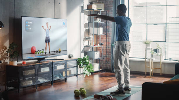 istock Strong Black Sportsman Does Workout Exercises at Home, Uses Online Exercise Courses, Personal Video Trainer in Streaming Fitness Tutorial. Strong and Handsome African American Male Athlete. 1461054765