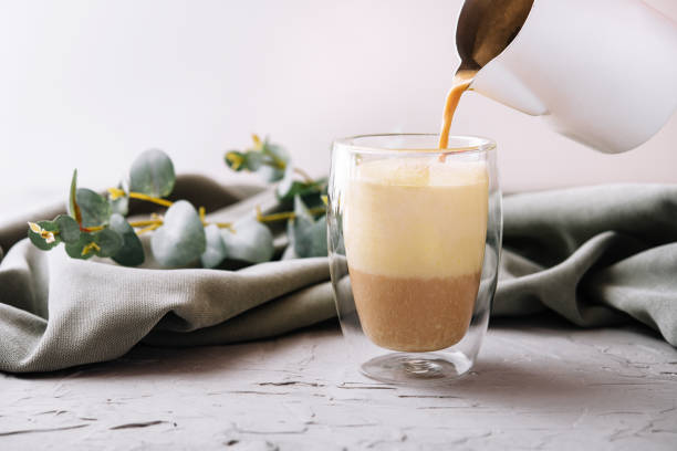 istock pouring a coffee with milk from teapot to glass cup 1461059076