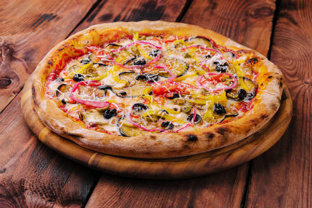 vegan pizza with eggplant, tomatoes and red onion stock photo
