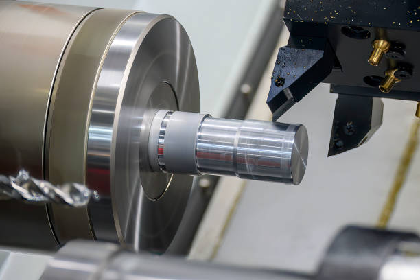 The  CNC lathe machine forming  cutting the metal shaft parts. stock photo