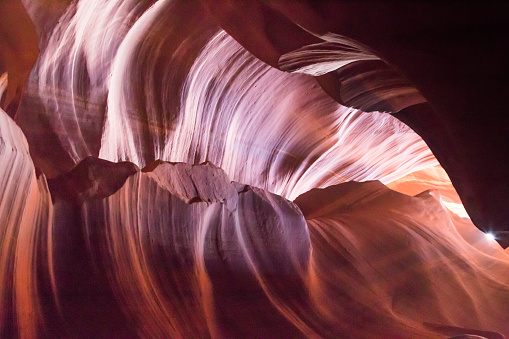 Colorful formations in Upper Antelope Canyon. Rock texture with pink, magenta and orange colors. Myriad of shadows and soft bright colors. Light showing off the glamorous detail of the ancient spiral rock arches.