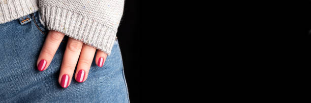 istock Hand with viva magenta nails on jeans banner 1461067483