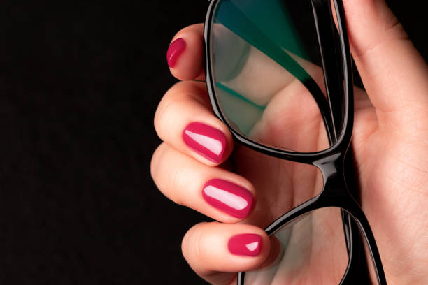 istock Hand with viva magenta, pink nails and glasses 1461067644