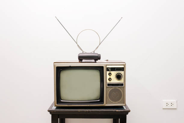 istock Retro old television with antenna on table in room with white background. Vintage style filtered photography 1461069286