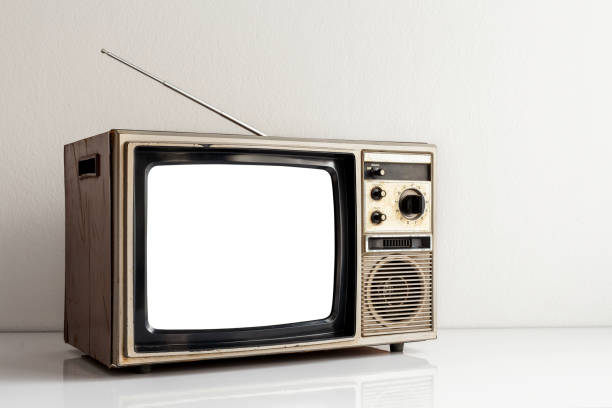 istock Vintage old television with cut out screen on white table and antenna in front of white wall background. 1461069342