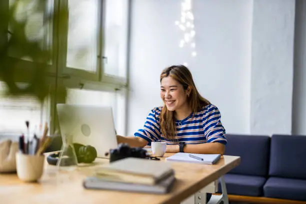 Young woman sitting at desk working on laptop