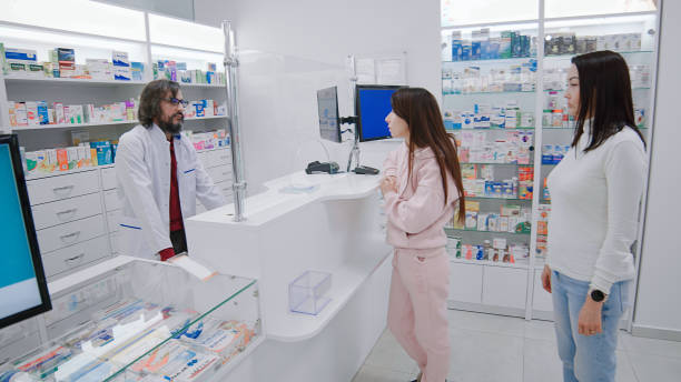 istock Pharmacis serves two customers at cash register 1461077402
