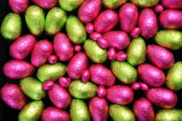 istock Pile or group of multi colored and different sizes of colourful foil wrapped chocolate easter eggs in lime green; yellow, and pink. 1461077711