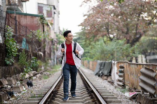 Asian Chinese mature man travel walking on rail way at Hanoi Vietnam