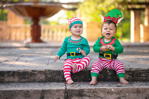 Kids dressed as Santa's helpers in a park