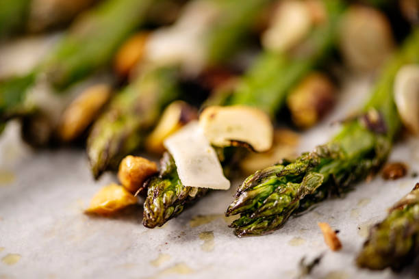 Close up of  asparagus stalks made with pistachios, capers, parmesan cheese, garlic and thyme. Colour, horizontal format with some copy space.