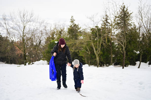 istock mom on a walk with her daughter in a snowy forest. 1461087283