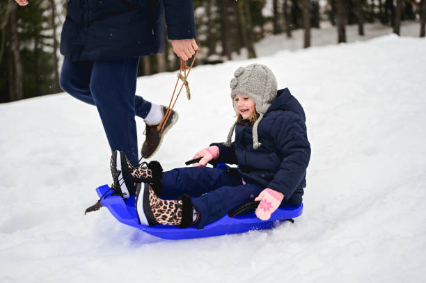 istock father sledding his little daughter on a sled 1461087807