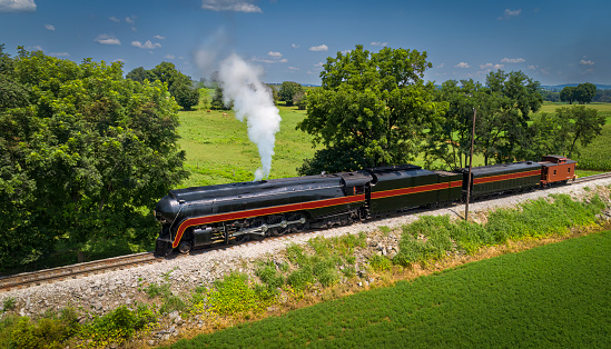 Coal burning K-36 steam locomotive moving toward camera on narrow gauge track.