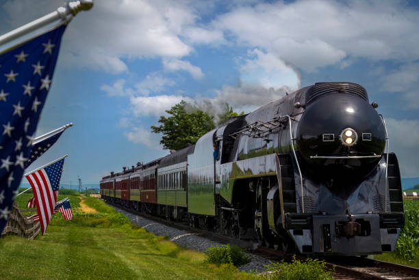 istock A Restored Steam Passenger Train Approaches As American Flags Wave on a Fence 1461088453