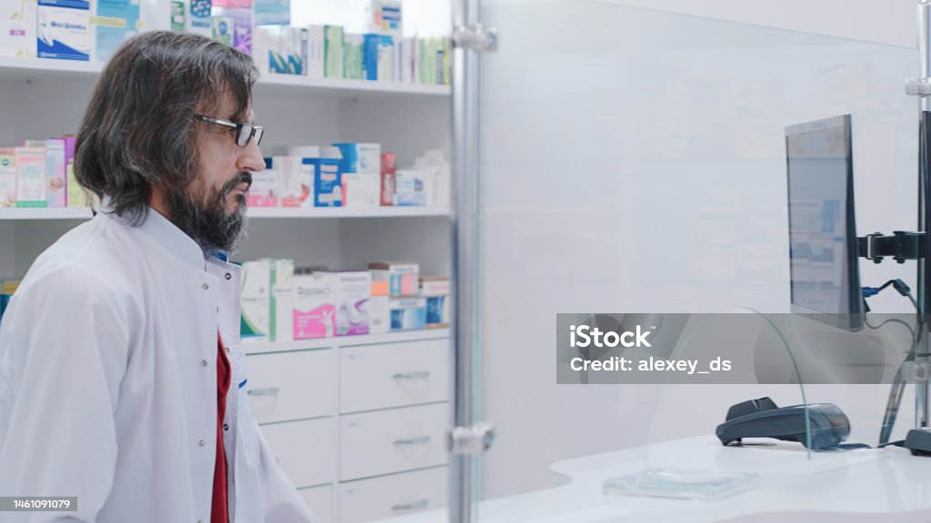 Pharmacis lavora al registratore di cassa - Foto stock royalty-free di 60-64 anni Pharmacis lavora al registratore di cassa - Foto stock royalty-free di 60-64 anni