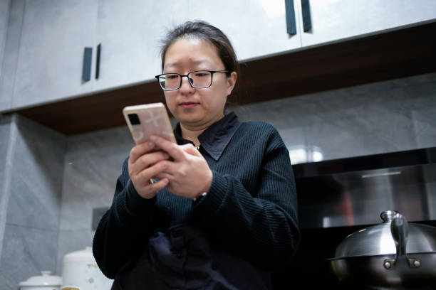 istock The woman is using her mobile phone in the kitchen 1461091383