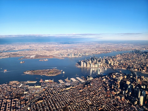 Aerial shot of NYC. Photo shows the southern tip of Manhattan, the downtown district of Brooklyn and Governors  Island. Freedom Tower (One World Trade Center) is prominent.   Both the Brooklyn Bridge and the Manhattan Bridge can be seen.  On the Brooklyn side, the Brooklyn Bridge Park and DUMBO can be seen. State of Liberty Island and Hoboken New Jersey are also in the photo.