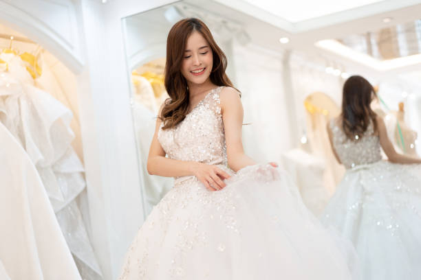 istock Asia young is smiling while choosing wedding dress in modern wedding salon 1461095877