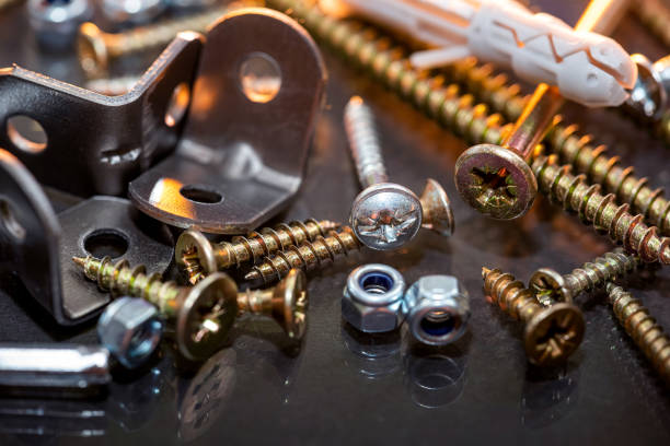 image of sets of plastic dowels shiny metal self-tapping screws in  pile on  table background. Close-up image of sets of plastic dowels and shiny metal self-tapping screws in a pile on a table background. Screws close up. bolt fastener stock pictures, royalty-free photos & images