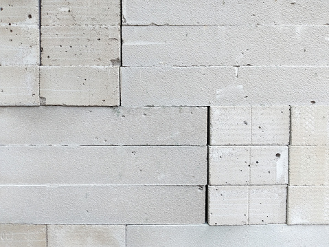 Texture of a light brick wall, white aerated concrete blocks for house building. Light weight construction structure in industry background