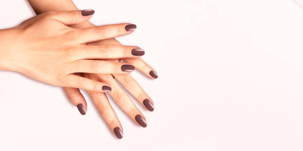 istock Womans hands with trendy manicure on brown background. Brown nail design 1461102629