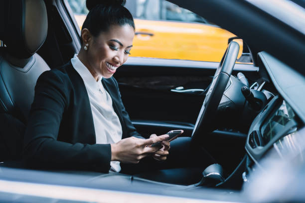 istock Cheerful ethnic businesswoman using smartphone in car 1461103261