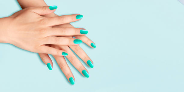 istock Womans hands with a a trendy manicure on light blue background. 1461103271
