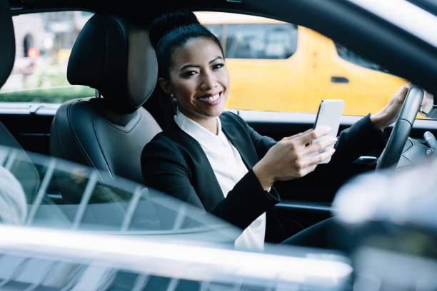 istock Optimistic entrepreneur driving car watching phone 1461103282