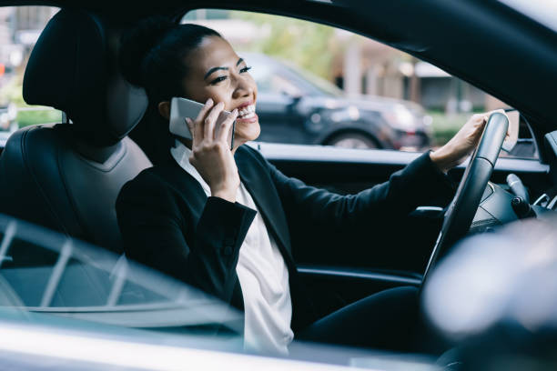 istock Excited boss driving car calling on smartphone 1461103315