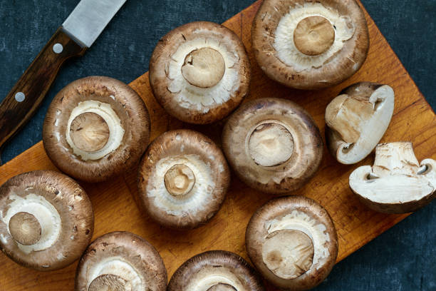 istock Fresh uncooked Royal Champignons on a wooden cutting board, top view 1461103652