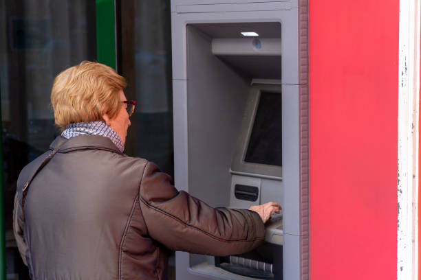 istock Elderly woman using the ATM bank 1461104134