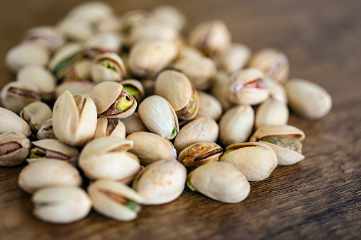 Group of organic pistachios on a cutting board.