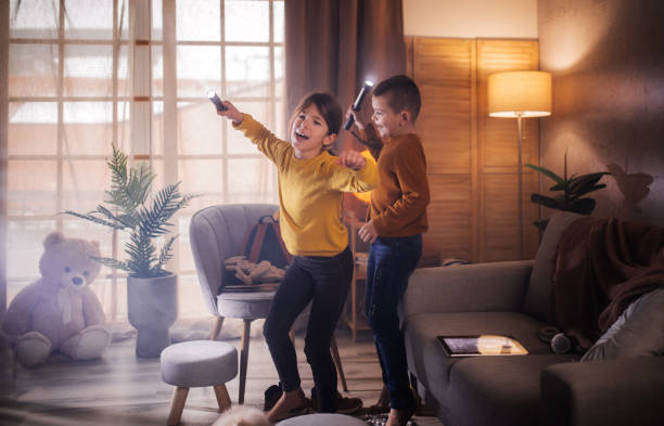 遊び時間に兄と遊ぶ幸せな若い女の子 - domestic life jumping child sofa ストックフォトと画像