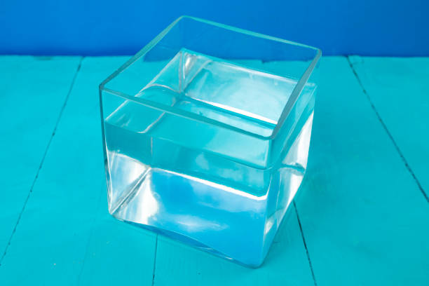 istock Glass cube filled with water on blue background 1461107753