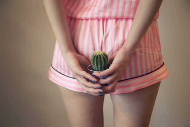 a girl in pajamas holds a cactus near the priests. Hemorrhoids, stool problems, bowel problems. postpartum hemorrhoids a girl in pajamas holds a cactus near the priests. Hemorrhoids, stool problems, bowel problems. postpartum hemorrhoids anus stock pictures, royalty-free photos & images