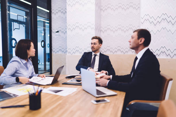 istock Employee sharing ideas with colleagues during meeting in conference room 1461109207