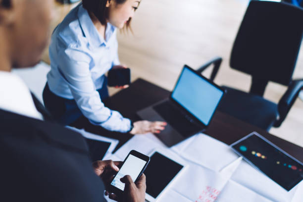 istock Diverse colleagues using smartphone and laptop for creating presentation in office 1461109515