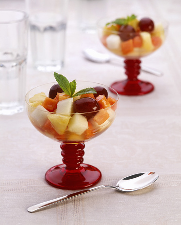 fruit salad with mint in glass bowl