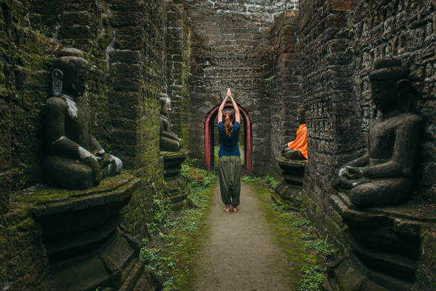 woman with raised hands in spiritual buddhist place - spiritual practices imagens e fotografias de stock