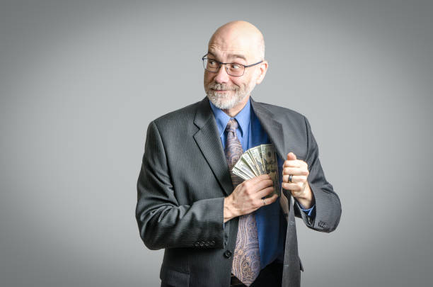 businessman putting money in his pocket - business person suspicion clothing well dressed imagens e fotografias de stock