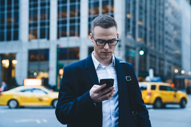 istock Serious man using smartphone near office building 1461116177