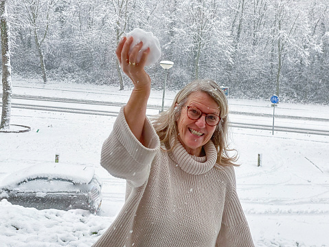 Woman having fun with trowing a snowball