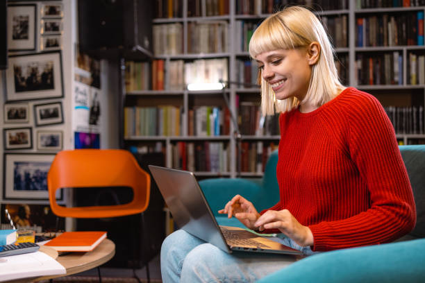 Female student using laptop in the library