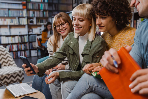 istock Group of young people using smart phone in the library 1461119500
