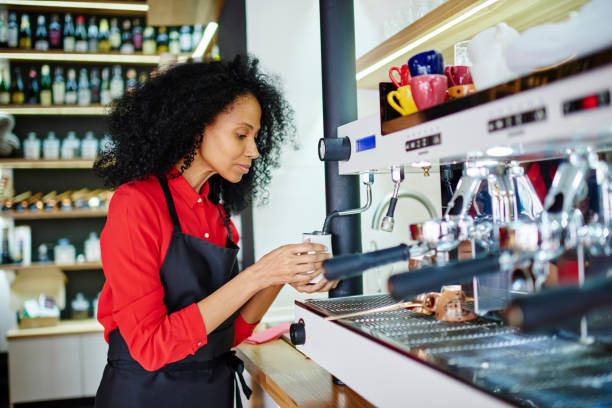 istock Black barista preparing beverage on coffee machine 1461120007