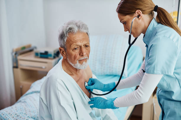 istock Female nurse using stethoscope while checking heartbeat of hospitalized senior man. 1461121999